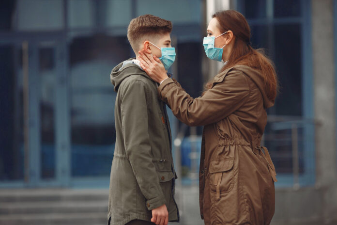 A boy and mother are wearing protective masks